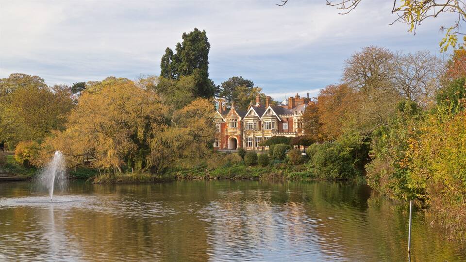 A historic house by a lake with a fountain.