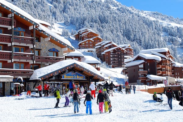 Station de ski de Méribel montrant neige et petite ville ou village aussi bien que petit groupe de personnes
