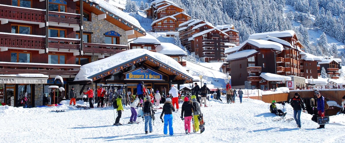 Meribel Ski Resort showing snow and a small town or village as well as a small group of people