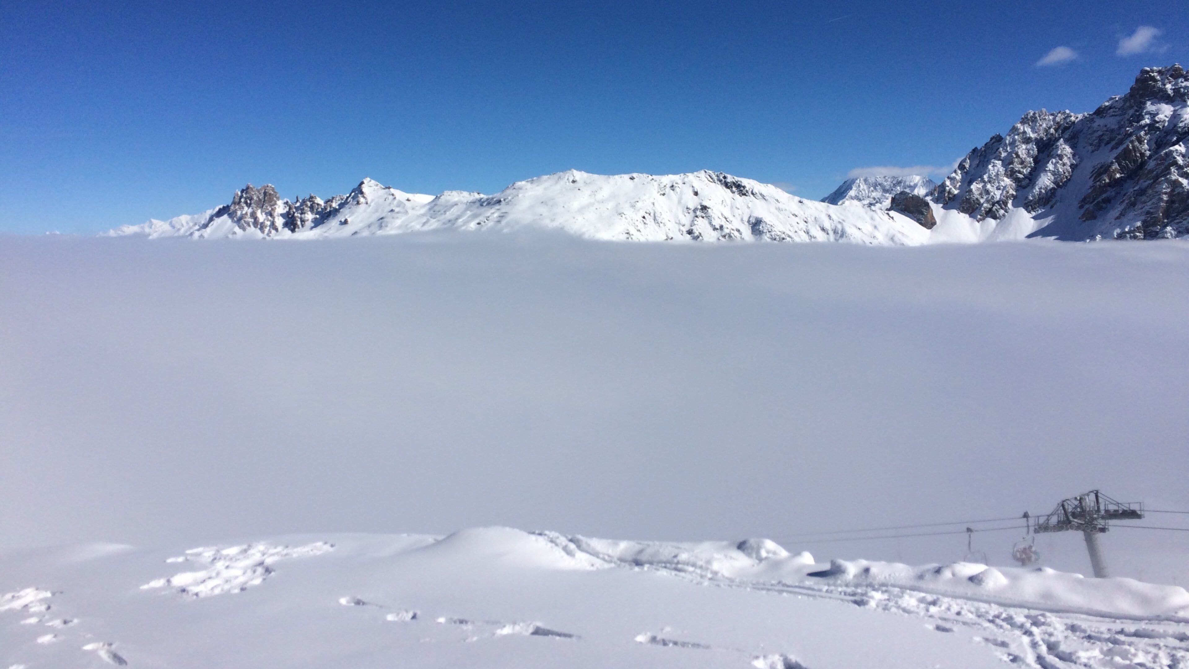 Meribelin hiihtokeskus joka esittää usvaa tai sumua, lunta ja vuoret