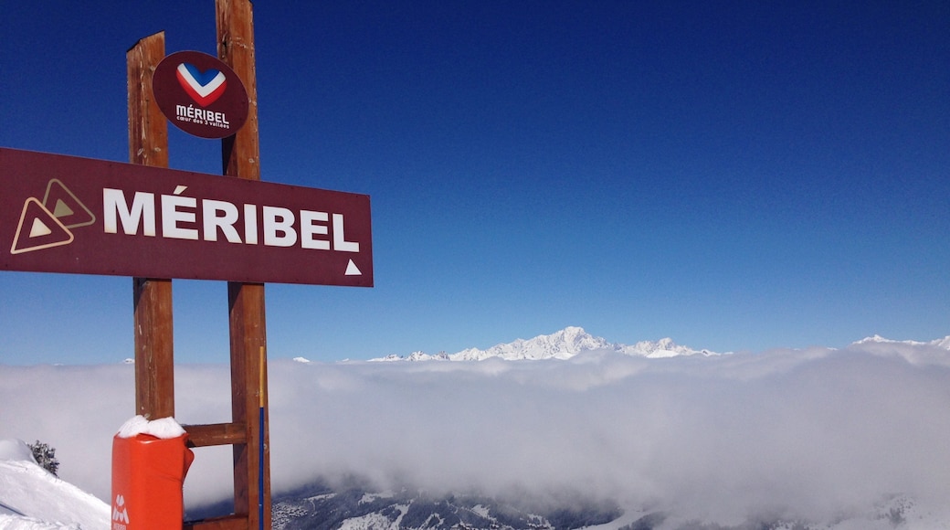 Meribelin hiihtokeskus johon kuuluu usvaa tai sumua, kyltit ja lunta