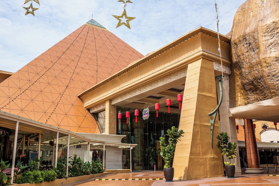 A building with a large, pyramid-shaped roof and a covered entrance area with red lanterns.