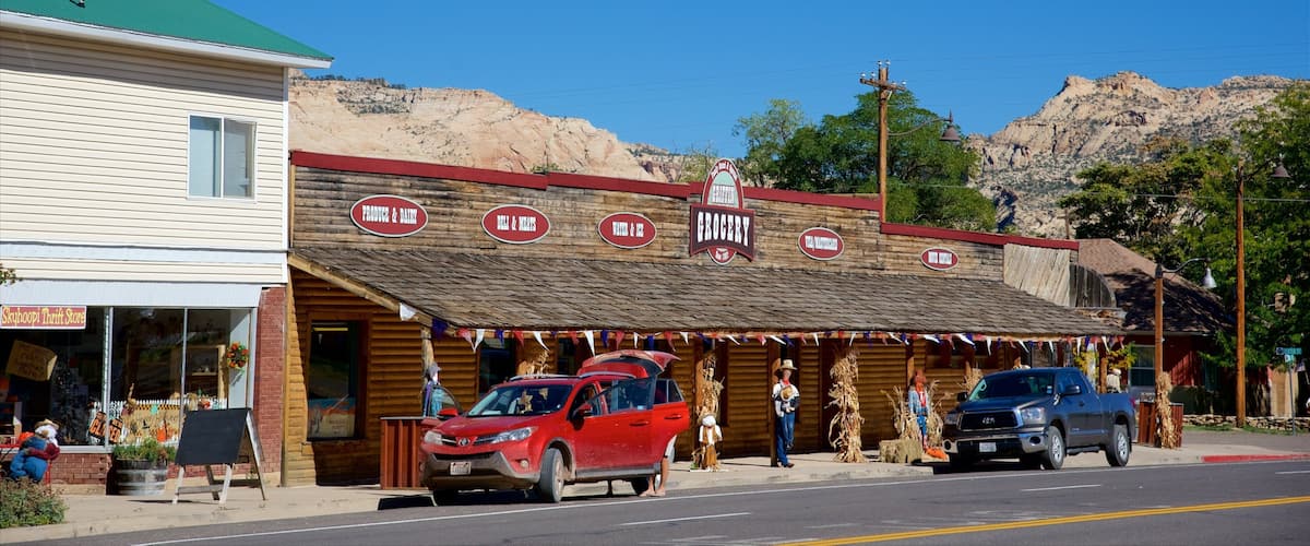 A rustic storefront with signs for produce, dairy, deli, meats, and grocery.