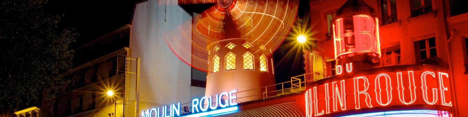 Moulin Rouge con letreros iluminados y una gran noria.