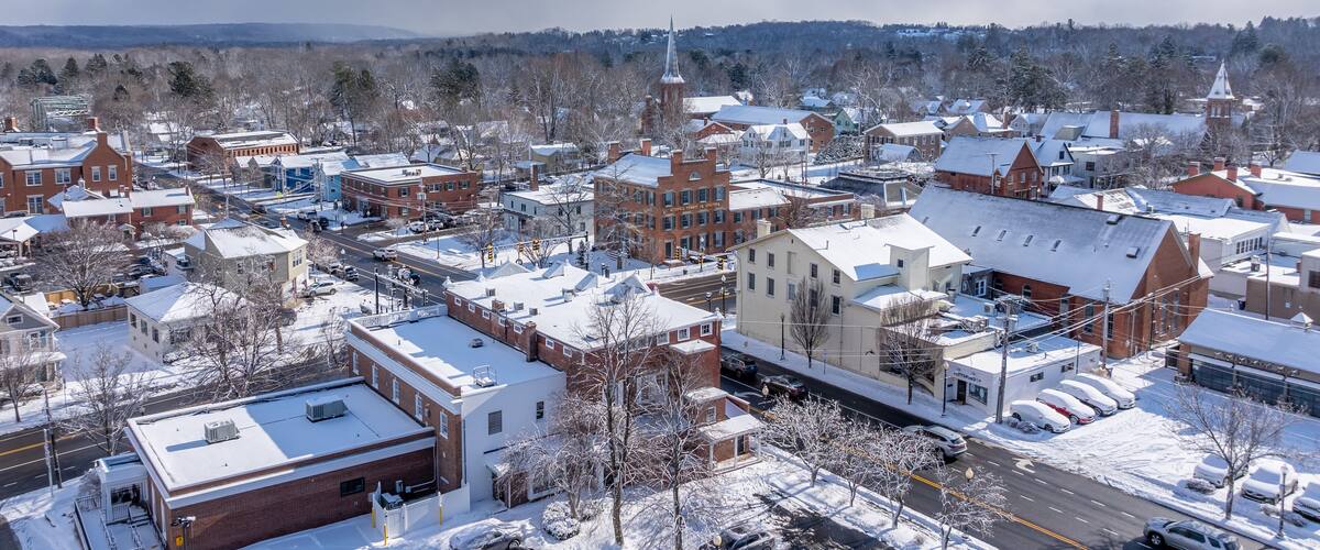 A snow-covered town with historic buildings and a church steeple.