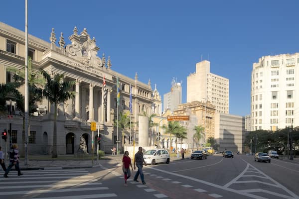 Une rue de la ville avec un bâtiment historique, des palmiers et des immeubles modernes.