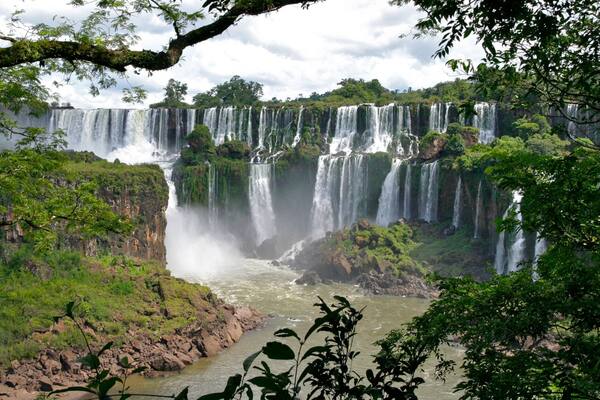 Uma cascata com vários níveis, rodeada por vegetação exuberante.