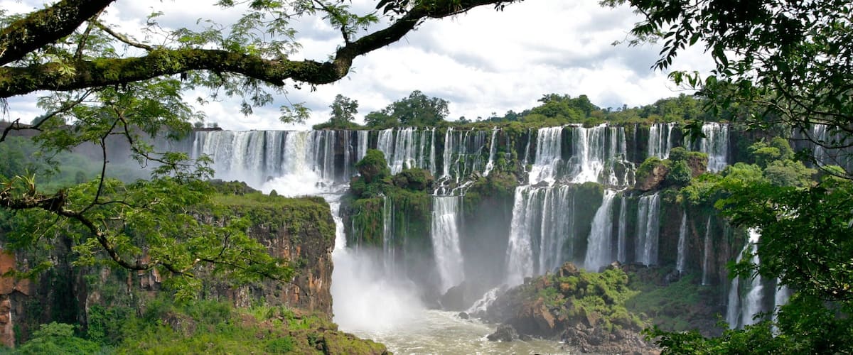 A multi-tiered waterfall surrounded by lush greenery.