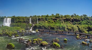 Eine Reihe von Wasserfällen, ein Fluss mit Felsen und eine Brücke.