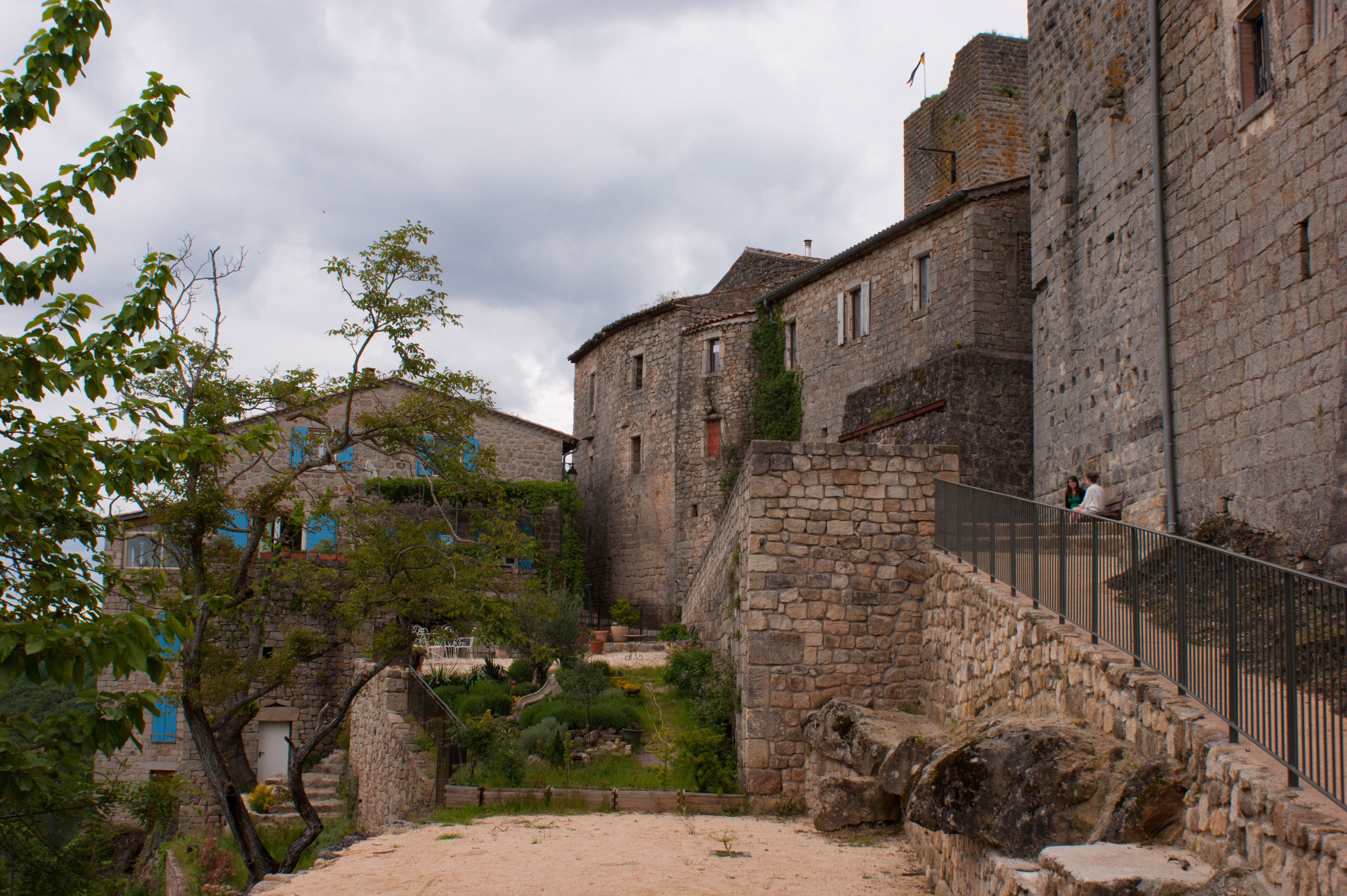 A historic stone building with a staircase and a fenced area.