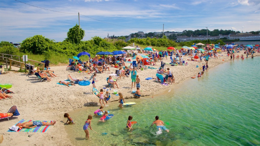Ogunquit Beach which includes a sandy beach and general coastal views as well as a large group of people