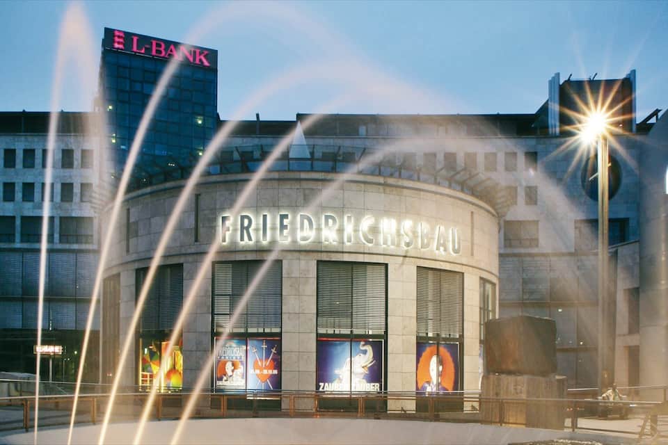 A building with the sign FRIEDRICHSBAU and a fountain in front.