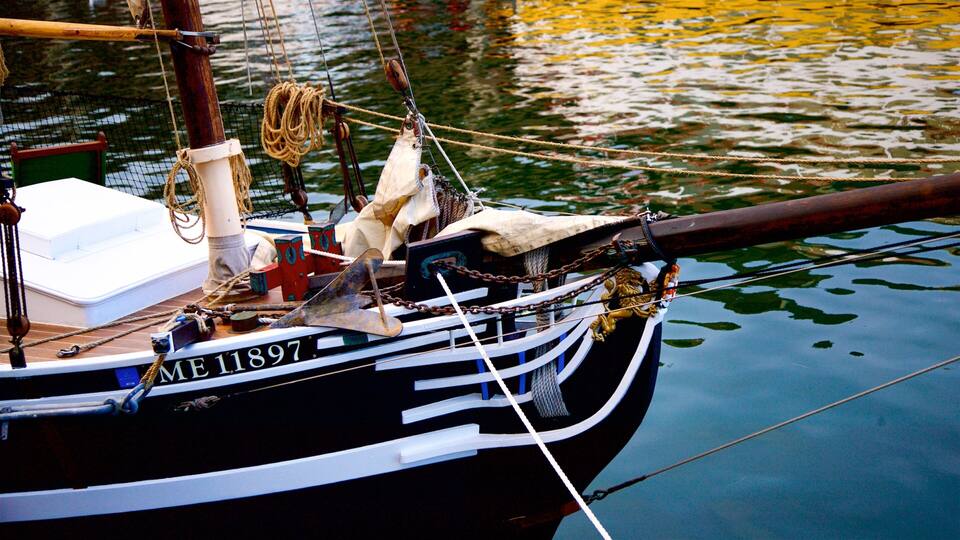 A boat with the number ME 11897 moored in calm water.