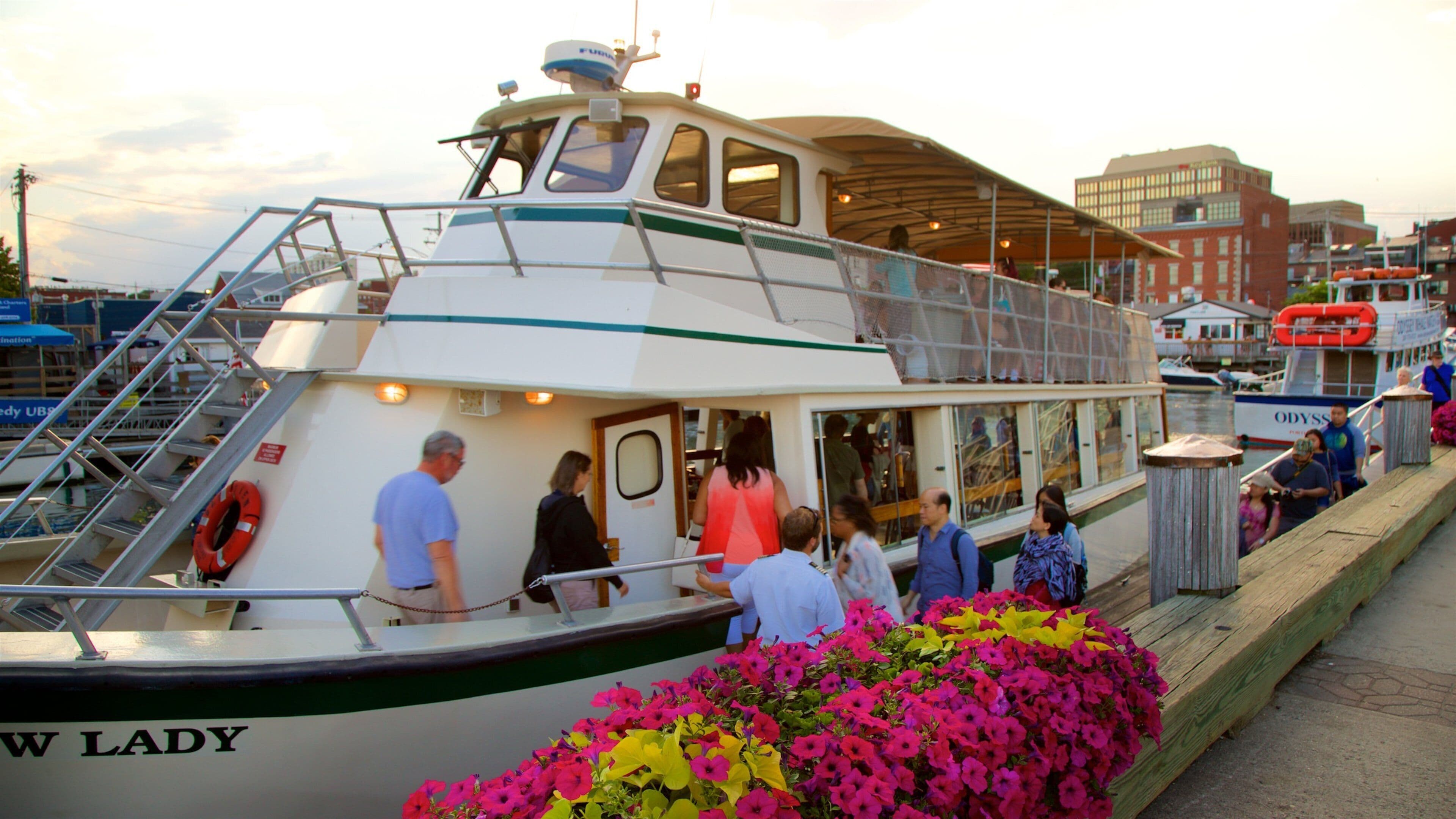 A white boat named 'W LADY' docked at a pier with people boarding and disembarking.