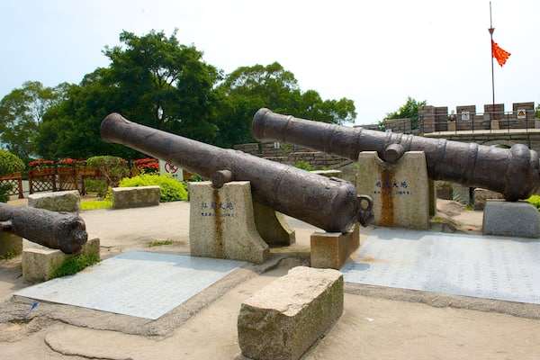 Three large cannons displayed outdoors with stone bases and inscriptions.