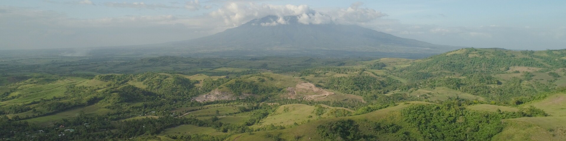Aerial view of mountain valley with hillscovered forest, trees, mount Iriga. Luzon, Philippines. Slopes of mountains with evergreen vegetation. Mountainous tropical landscape.