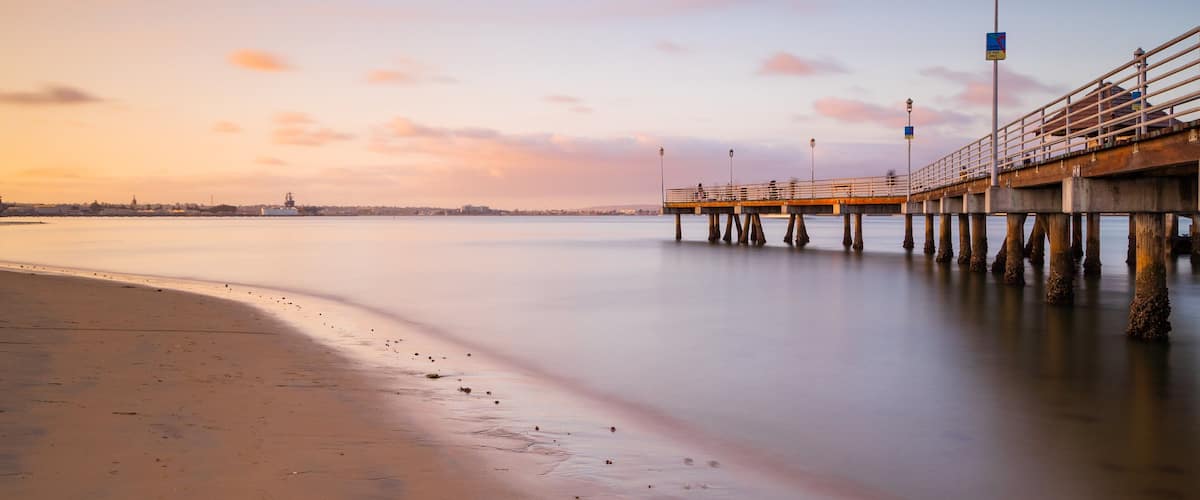 Coronado Ferry Landing featuring general coastal views, a sandy beach and a sunset