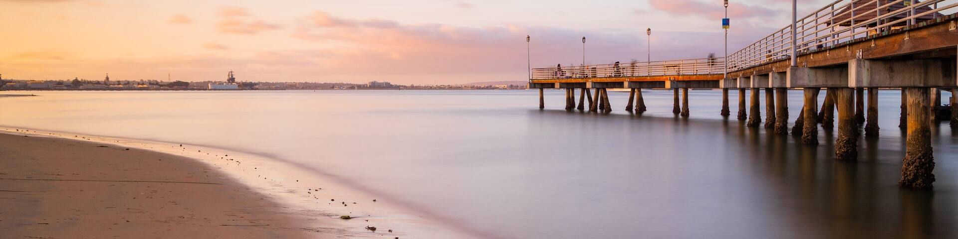 Coronado Ferry Landing featuring general coastal views, a sandy beach and a sunset