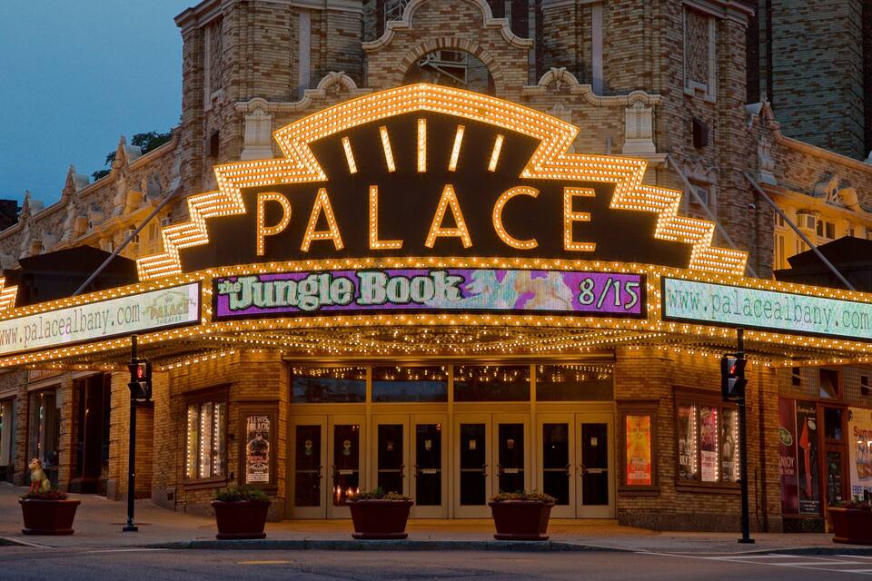 A theater with a marquee reading "PALACE" and "Jungle Book" with a date of 8/15.