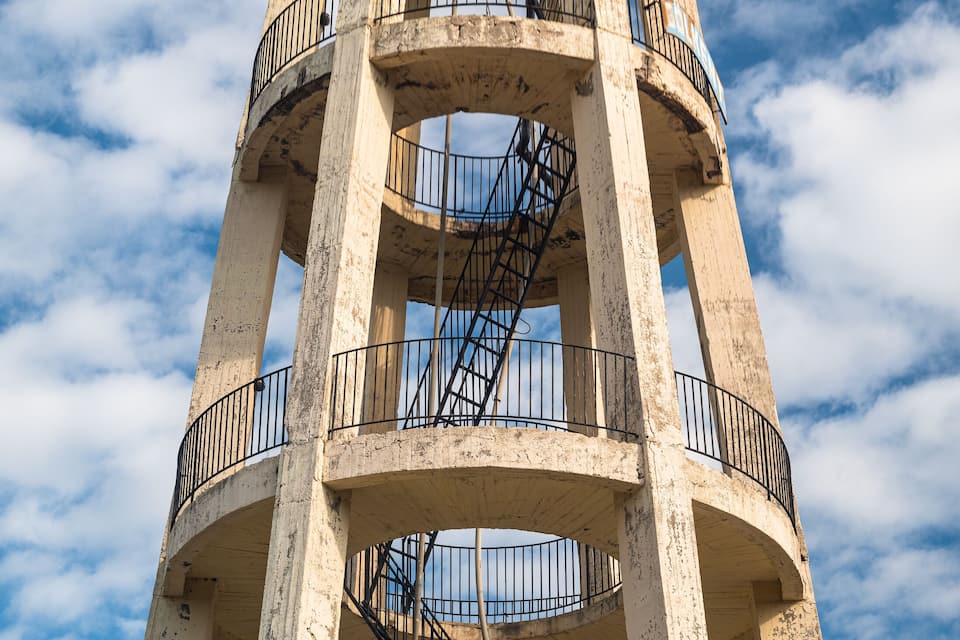 A large, cylindrical water tower with multiple balconies and a spiral staircase.