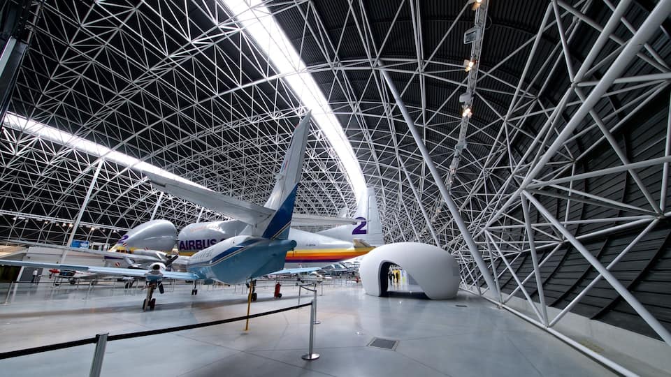 An airplane exhibition in a modern, glass-domed building with a steel framework.