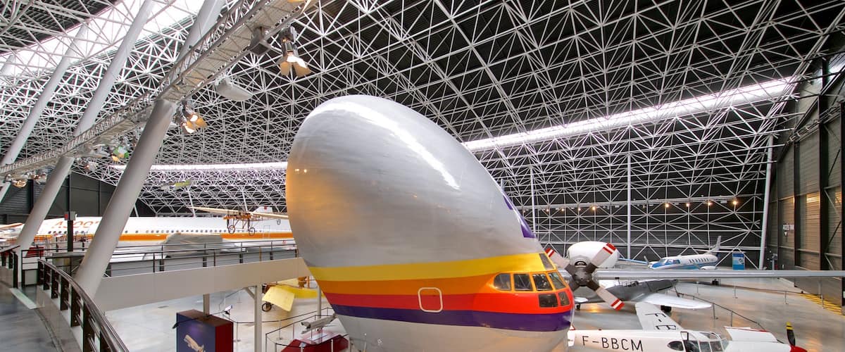 A large airplane with a rainbow stripe parked inside a hangar.