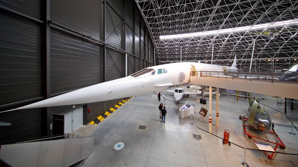 A white aircraft with a pointed nose inside a hangar.