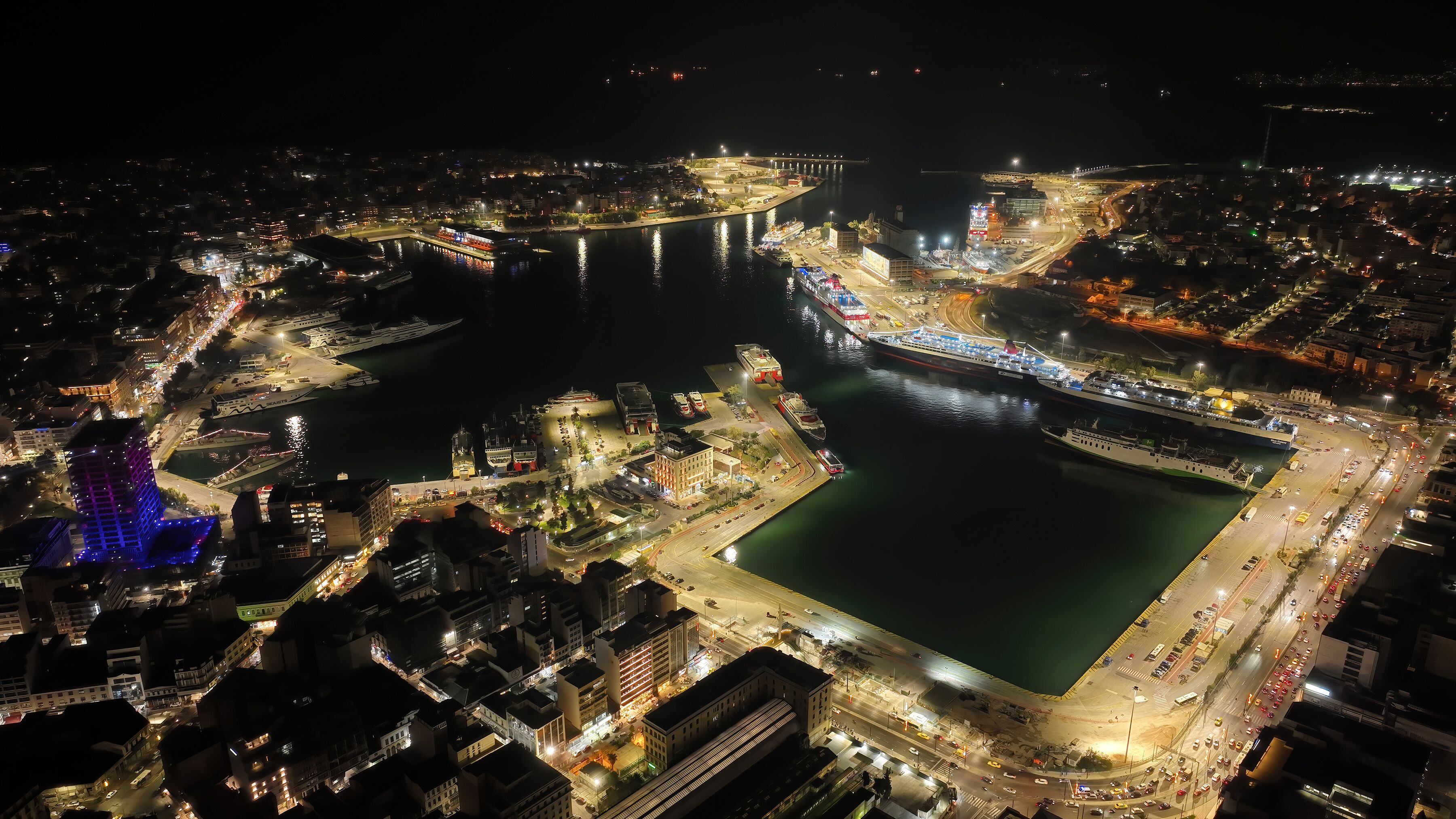 Aerial drone night shot of illuminated tower of Piraeus and port of Piraeus during Christmas period, Attica, Greece