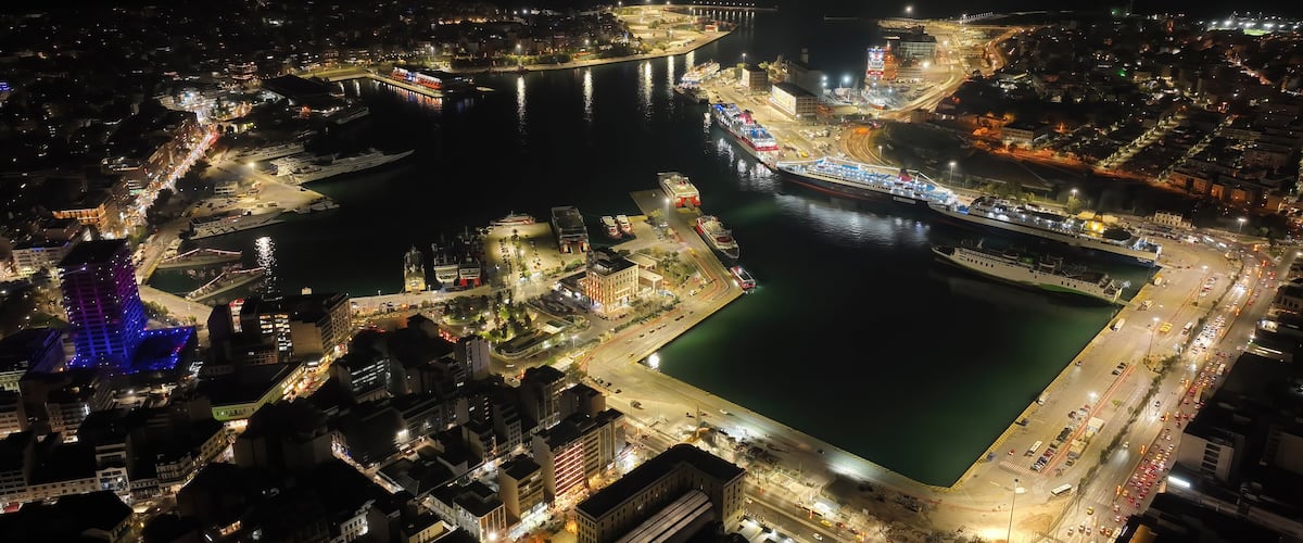 Aerial drone night shot of illuminated tower of Piraeus and port of Piraeus during Christmas period, Attica, Greece