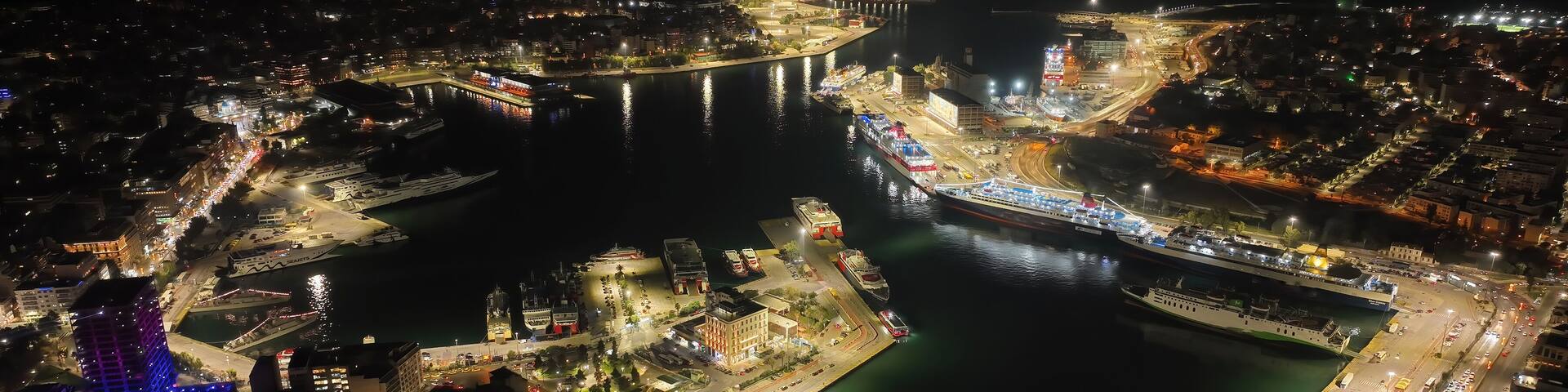 Aerial drone night shot of illuminated tower of Piraeus and port of Piraeus during Christmas period, Attica, Greece