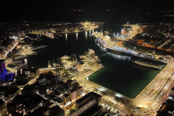 Aerial drone night shot of illuminated tower of Piraeus and port of Piraeus during Christmas period, Attica, Greece