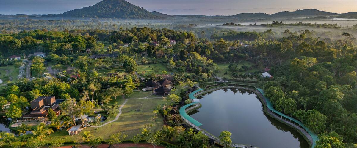Aerial Cinematic View of Gunung Bintan with Morning Fog and Reflections in Lake, Bintan Island, Indonesia