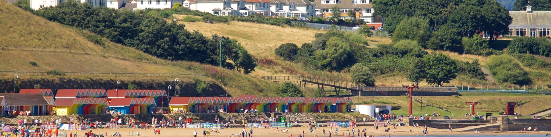 North Bay Beach showing a sandy beach and a coastal town as well as a large group of people