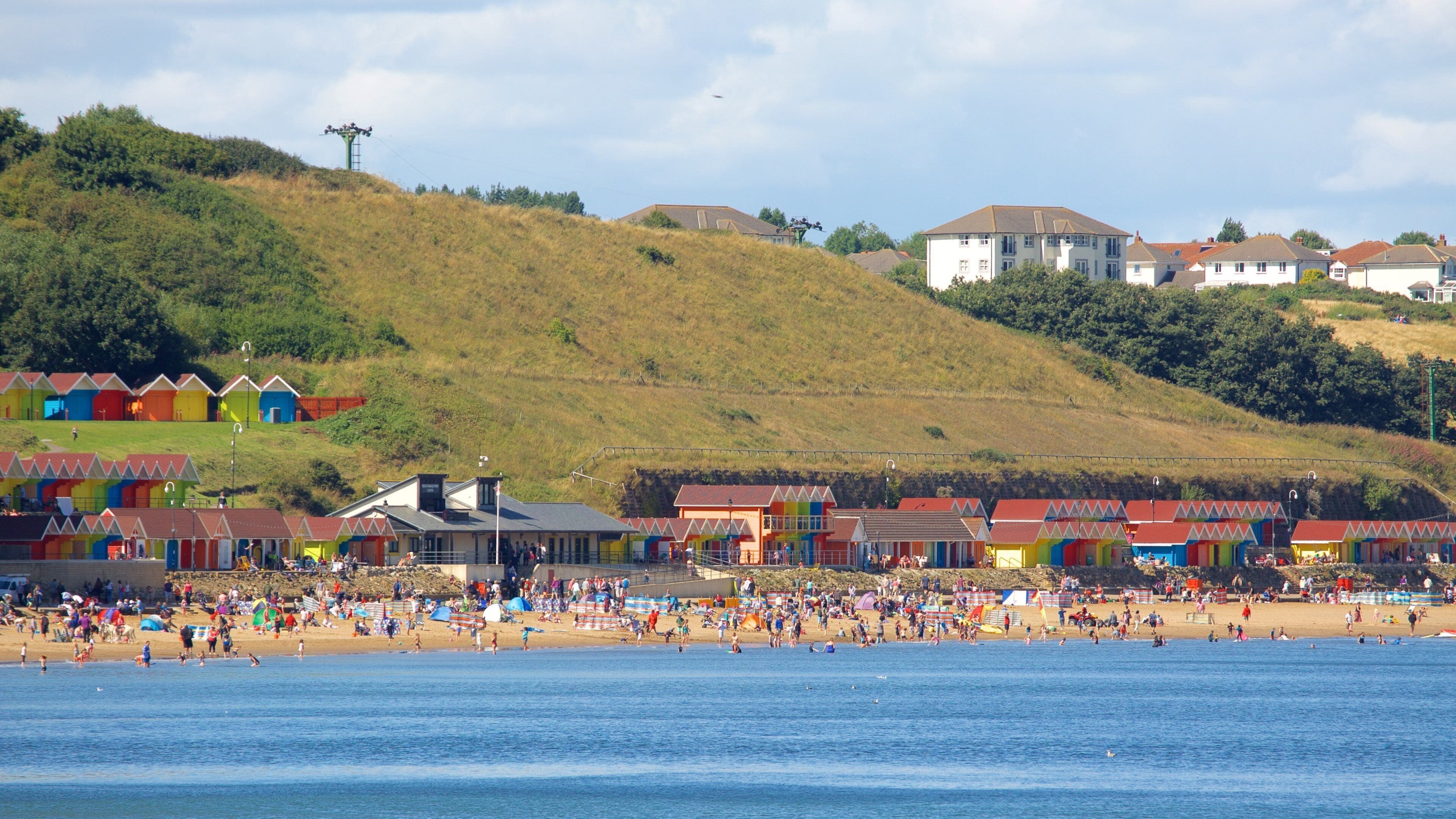 North Bay Beach featuring a beach and a coastal town as well as a large group of people