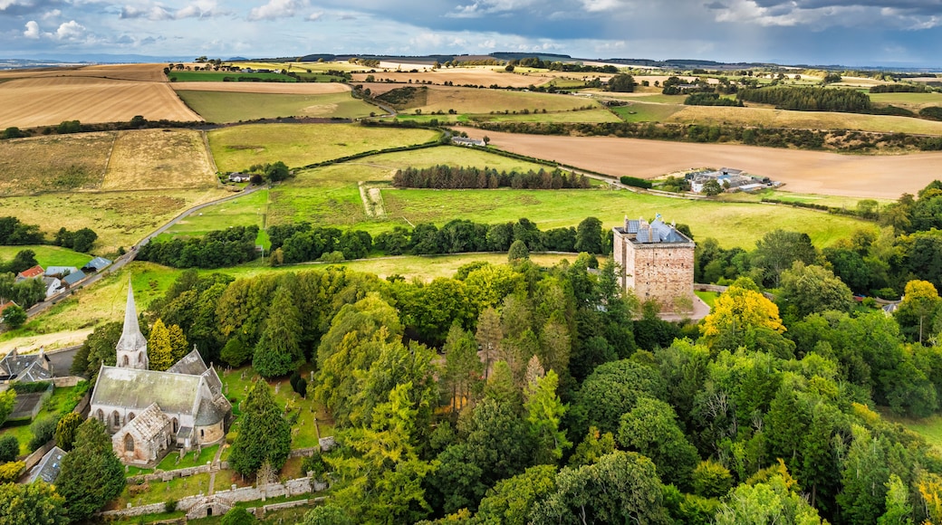 A rural landscape with fields, a church, and a castle.