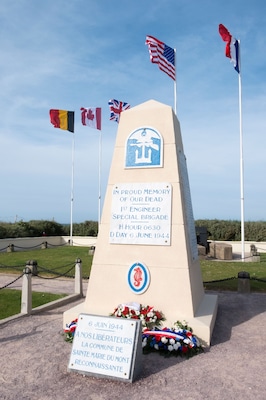 A memorial monument with flags, commemorating a fallen engineer.
