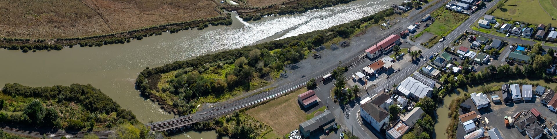 Aerial view of the town of Helensville, New Zealand, showing the town's layout, and the surrounding farmland. The photo shows the town's location and its relationship to the environment.
