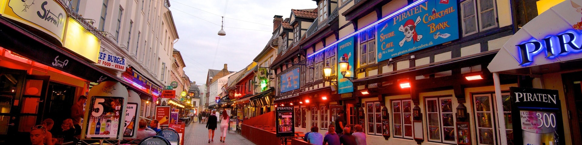 Calle Jomfru Ane Gade ofreciendo señalización, comidas al aire libre y arquitectura patrimonial