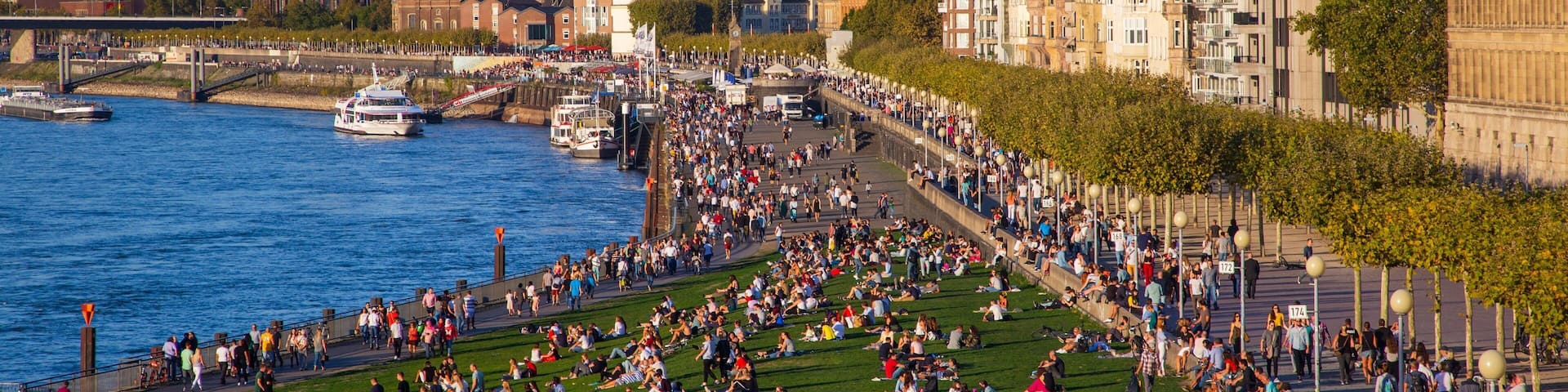 Düsseldorf Old Town featuring a city and a river or creek as well as a large group of people