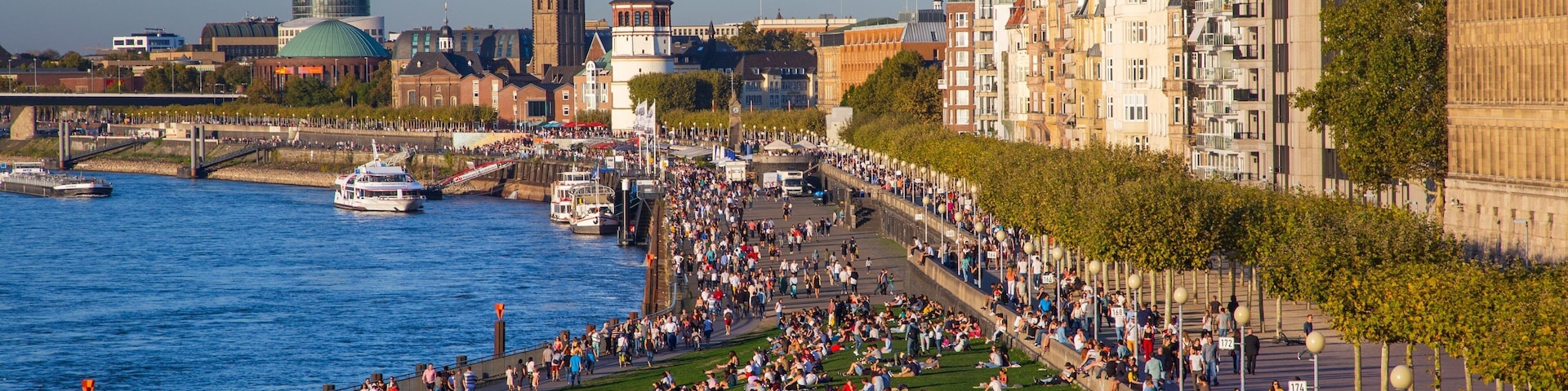 Düsseldorf Old Town featuring a city and a river or creek as well as a large group of people