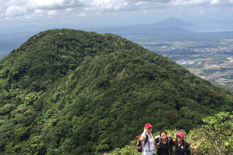 A lush green mountain with hikers.
