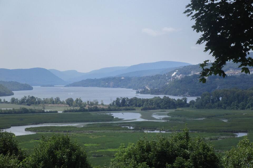 A river winding through a green landscape with hills in the background.