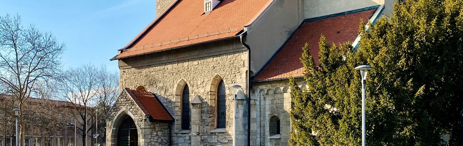 A church with a red roof and a stone tower.