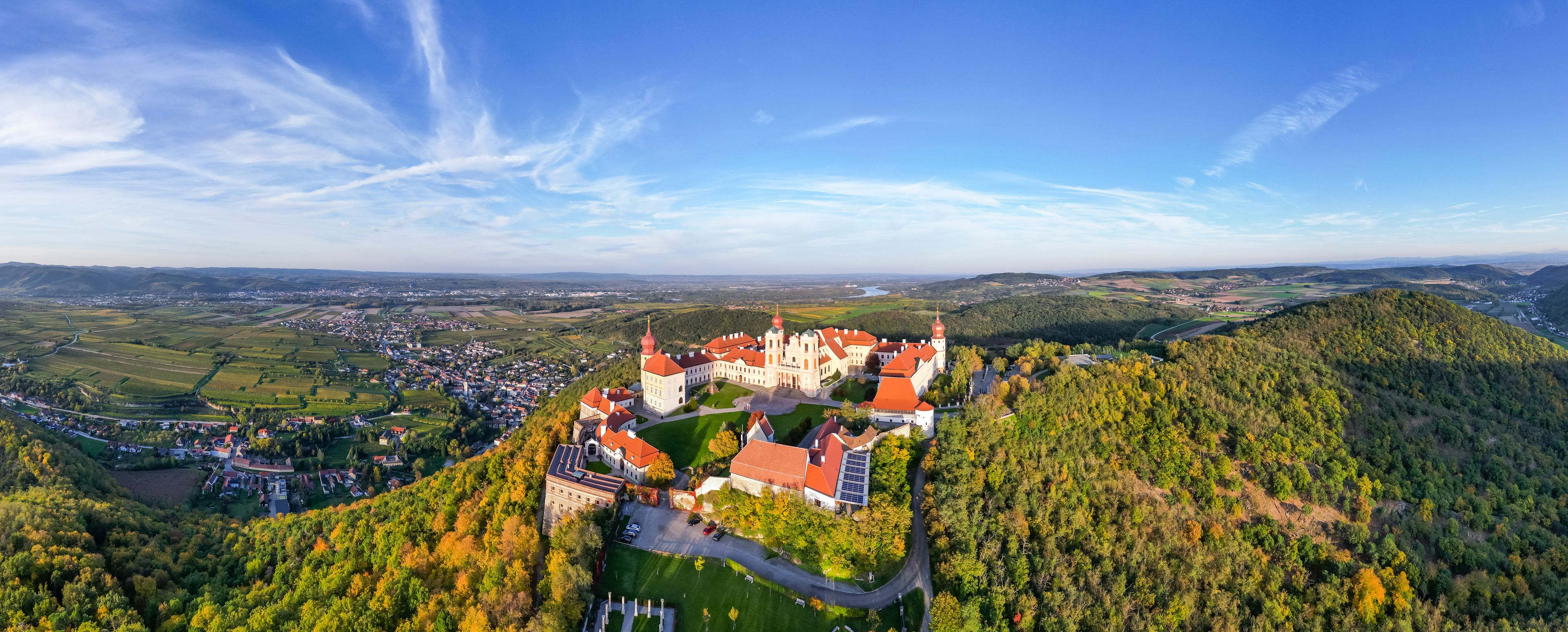 Un castello su una collina che domina una città e la campagna circostante.