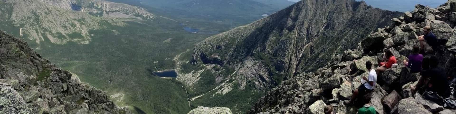 A mountainous landscape with rocky terrain and a valley below.