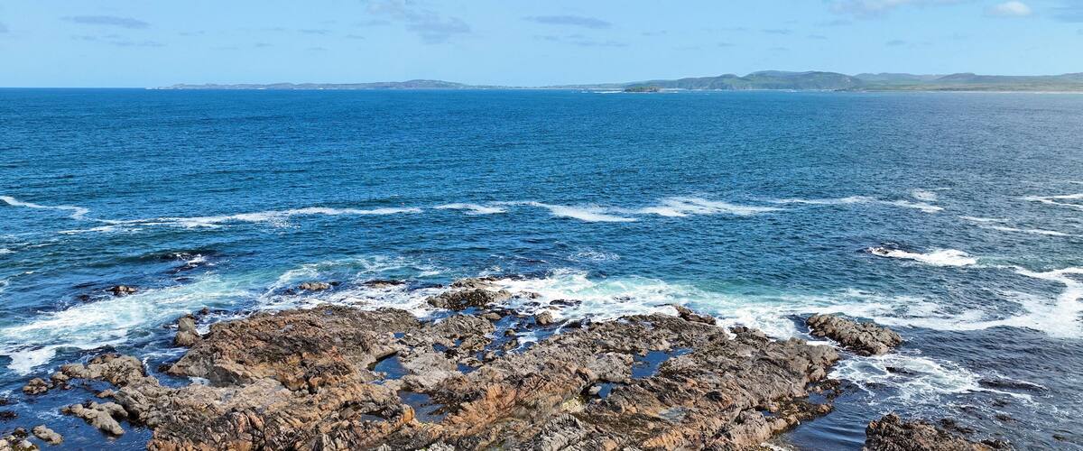 A rocky coastline with waves crashing against the rocks.