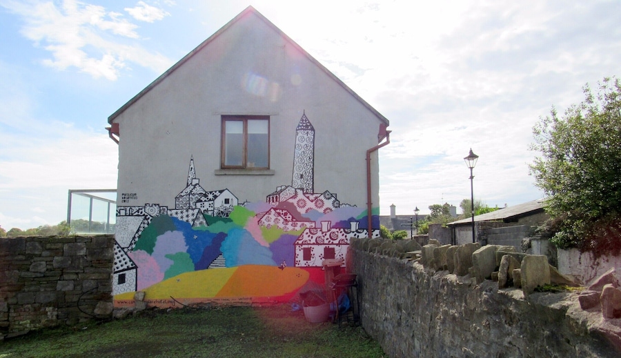 We were passing through Killala and saw a Round Tower (the Killala Round Tower), while walking around to get a better view of the Tower we spotted this mural on the side of a Home.