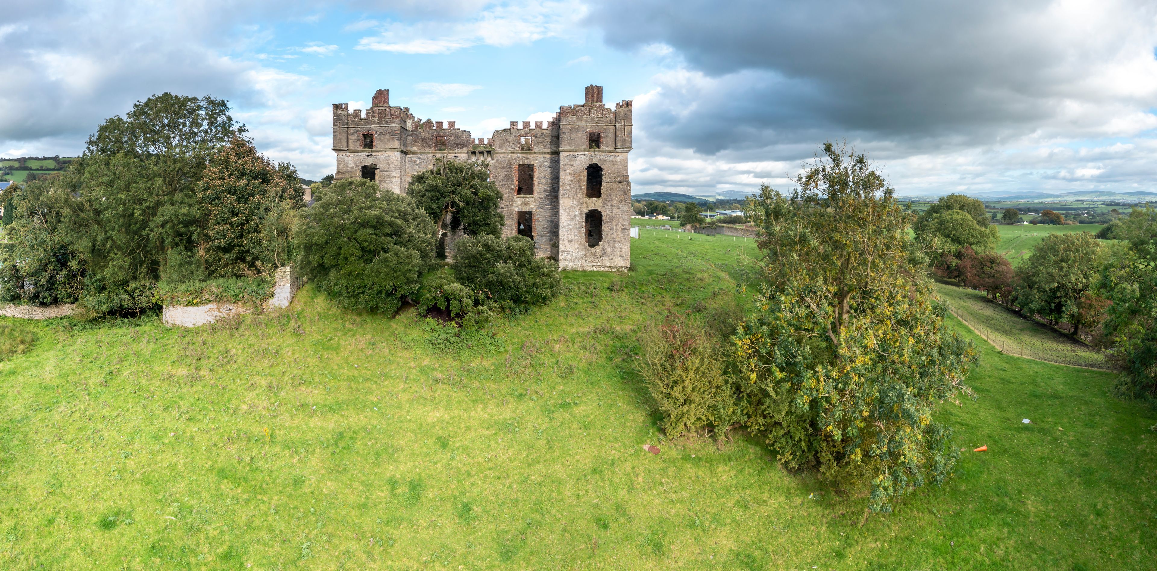 Un castello medievale immerso nel verde, circondato da dolci colline.