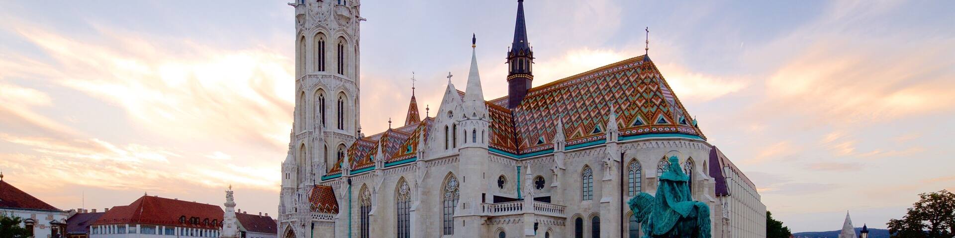 A historic cathedral with a tall spire and a colorful roof.