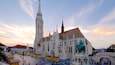 A historic cathedral with a tall spire and a colorful roof.